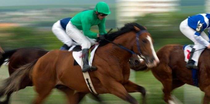 Atletas de jóquei correndo com cavalos