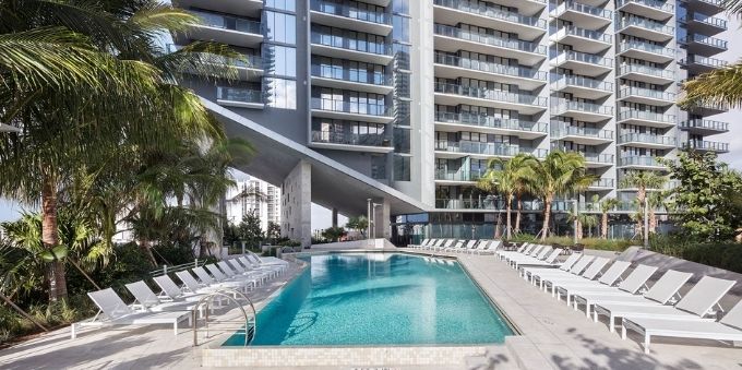 Imagem de área da piscina, com cadeiras para tomar sol ao redor, em hotel em Miami