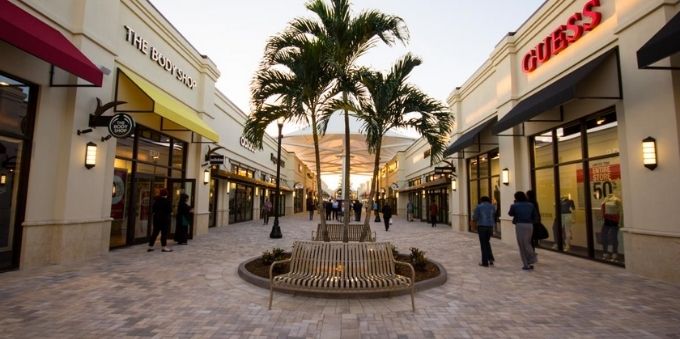 Miami: imagem a ceú aberto mostra pequeno centro comercial, sem muita circulação de pessoas, com árvore no meio