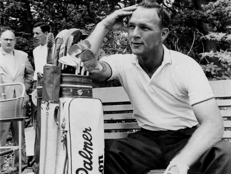 Arnold Palmer sentado em baco de madeira apoiado