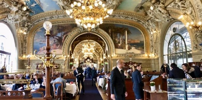 Imagem interna de restaurante chique em Paris mostra pessoas frequentando o local