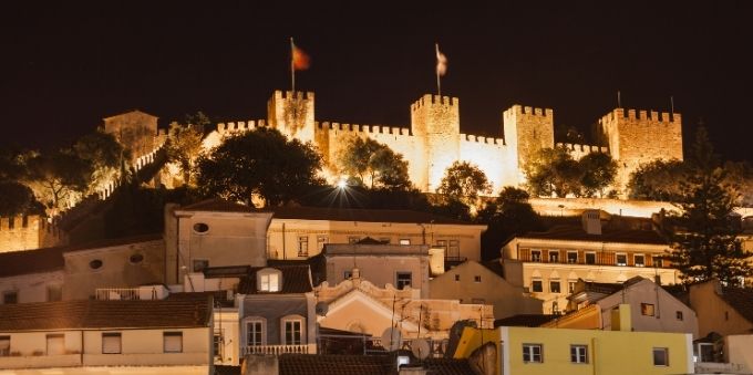 Imagem noturna do Castelo de São Jorge iluminado por luzes