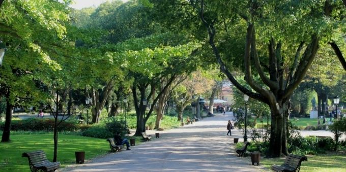 Imagem mostra parque, com caminha de pedras no meio, bancos e árvores ao redor, em Lisboa