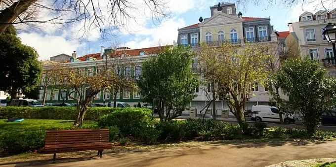 Imagem externa prédios clássicos no bairro Príncipe Real. em Lisboa, com banco na frente 