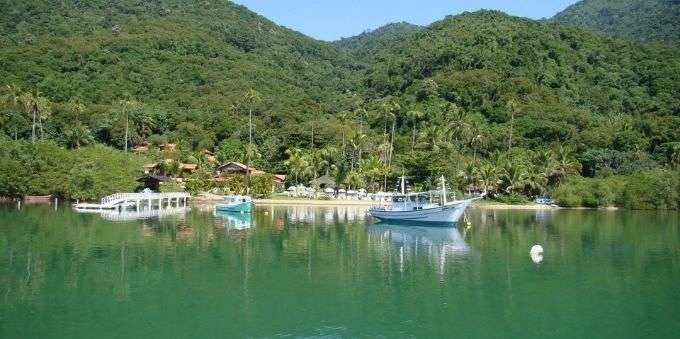 Imagem da praia, com barcos parados, em Angra dos Reis 